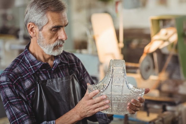 Free photo glassblower examining glassware