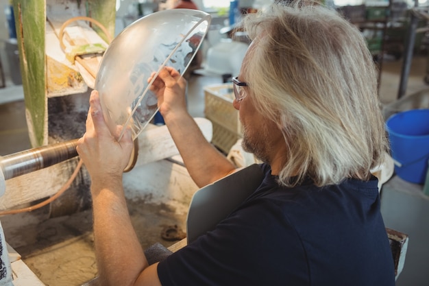Glassblower polishing and grinding a glassware