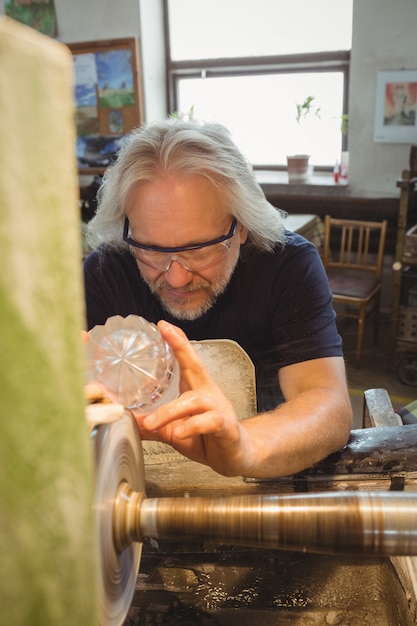 Glassblower polishing and grinding a glassware