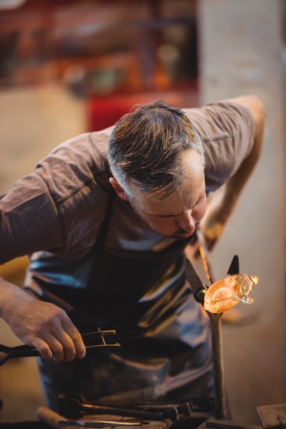 Glassblower shaping a molten glass