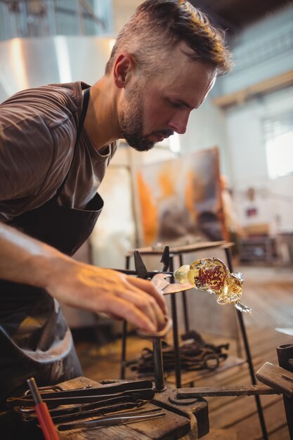 Glassblower shaping a molten glass