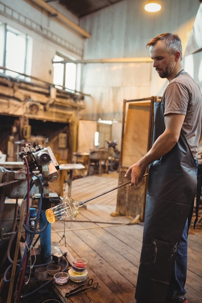 Glassblower shaping a molten glass