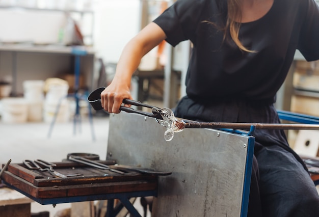 A glassblower student tries to make a flower out of glass