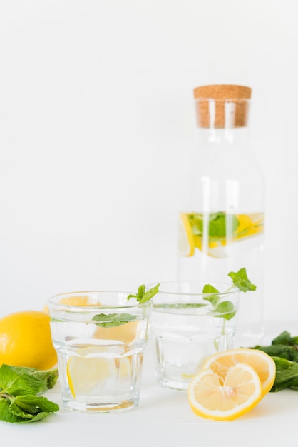 Стаканы и бутылка с лимонным мятным напитком