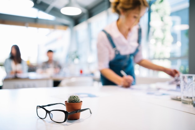 Glasses and cactus in office