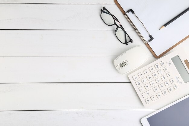 Очки, калькулятор и планшет на белом фоне аккуратный стол