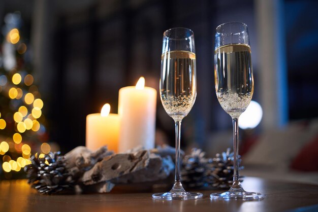 Glasses of champagne standing on table with christmas decor