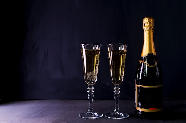 Glasses of champagne with bottle on table