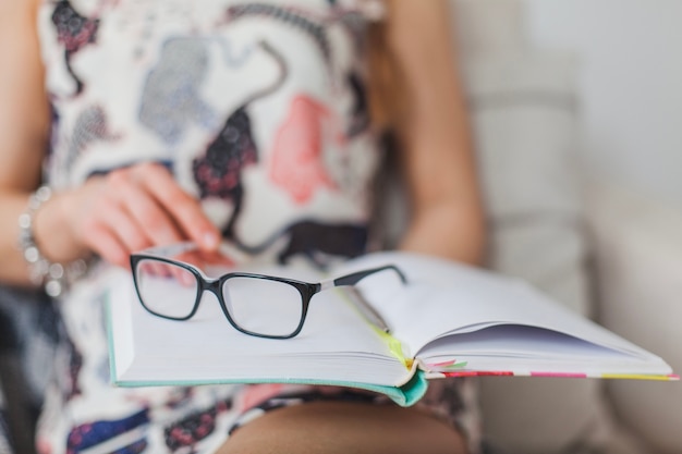 Glasses on diary with woman in background