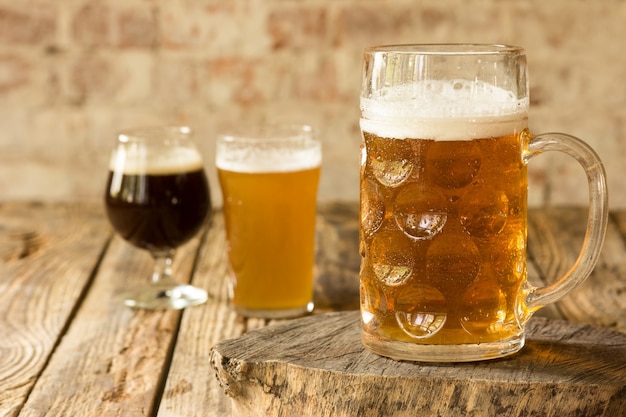 木製のテーブルにさまざまな種類のダークビールとライトビールのグラス