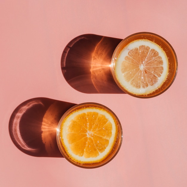 Glasses filled with water and slices of orange top view