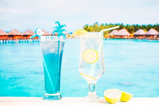 Glasses of fresh blue lemon drink with straw and sliced lime