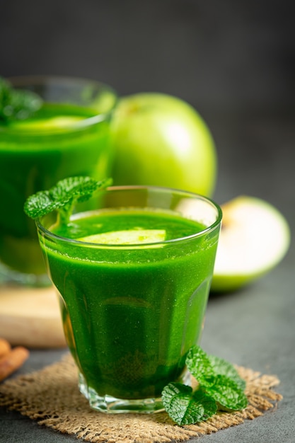Glasses of green apple healthy smoothie put next to fresh green apples
