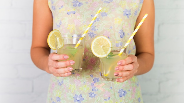 Glasses of lemonade held by a woman