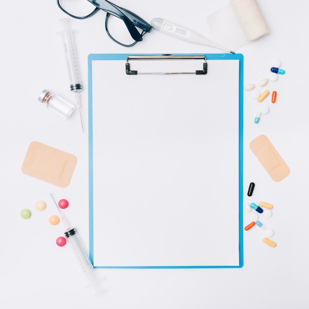 Glasses and medications around clipboard