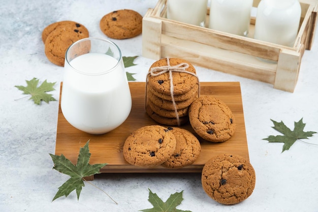 Стаканы молока с шоколадным печеньем и листьями.