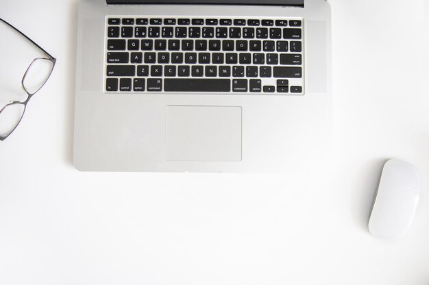 Glasses and mouse near laptop