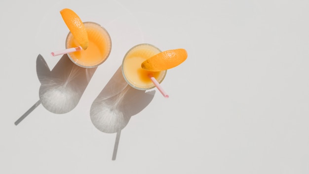 Glasses of natural juice of oranges with shadows top view