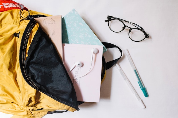 Glasses near backpack with notebooks