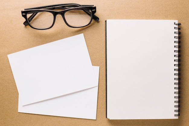 Glasses near notebook and paper sheets