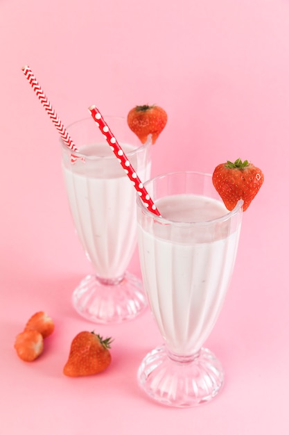 Бесплатное фото Очки клубничный молочный коктейль с розовым фоном