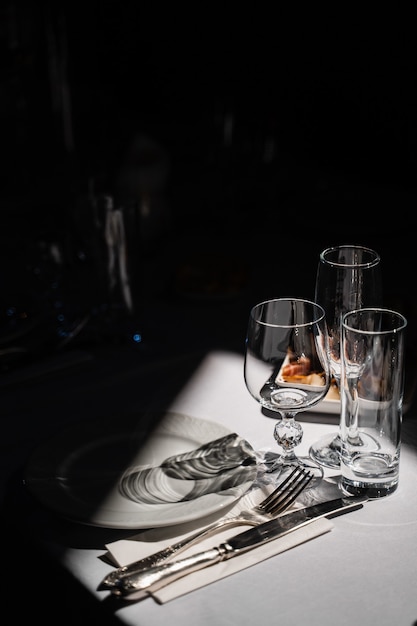 테이블에 안경, 접시 및 칼 붙이. 레스토랑의 테이블 세팅. 프리미엄 사진