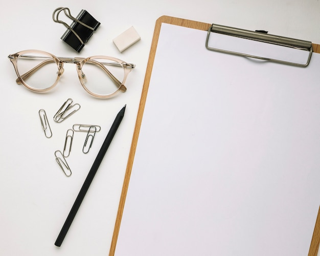 Glasses and stationery near clipboard