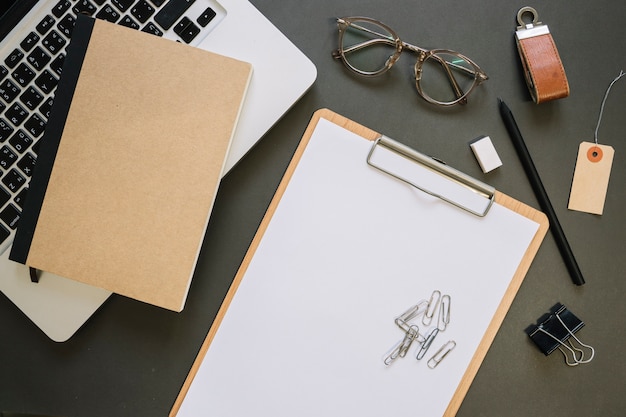 Glasses and stationery near laptop