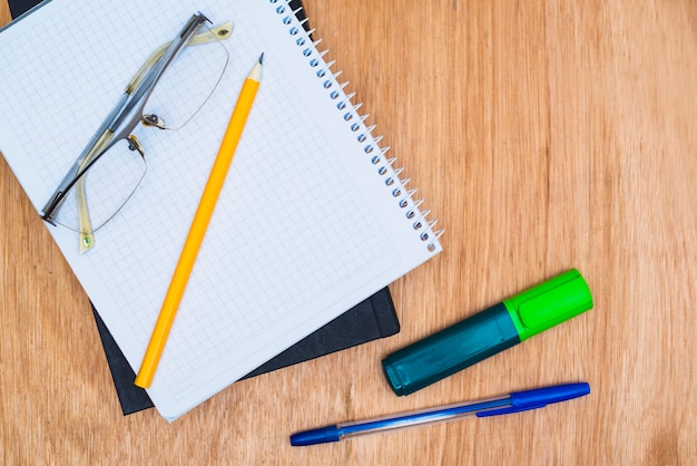 Glasses on stationery and textbook