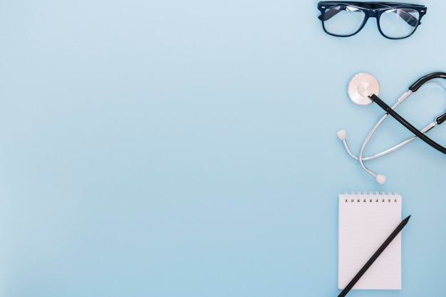 Glasses and stethoscope near notebook