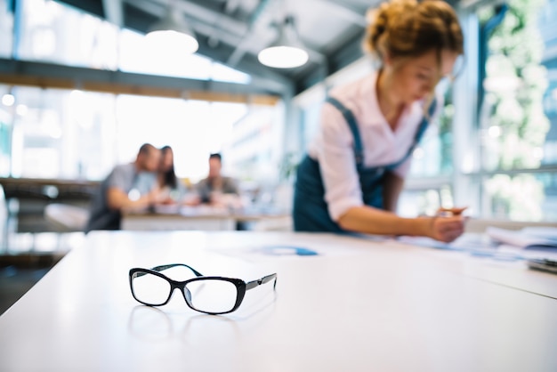 Free photo glasses on table of working woman