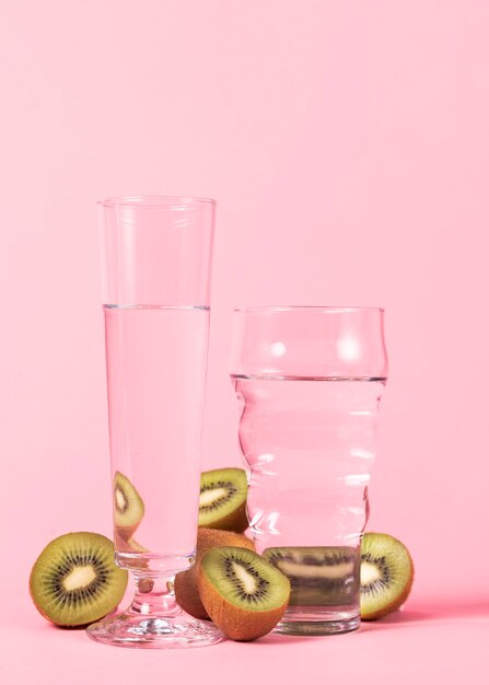 Glasses of water and sliced kiwi fruits