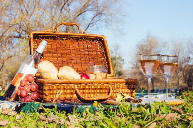 Бокалы с вином рядом с корзиной для пикника