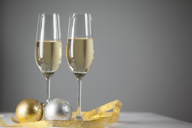 Glasses with champagne and gifts background