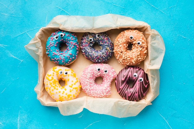 Free photo glazed donuts with eyes top view