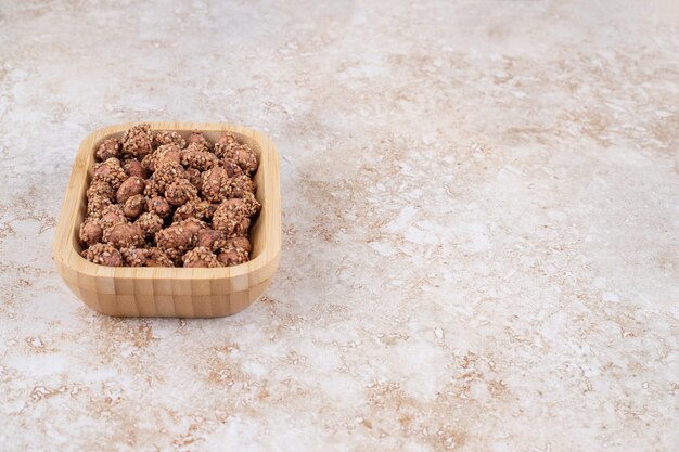 Glazed peanut with sesame on a wooden tray , on the marble table. 