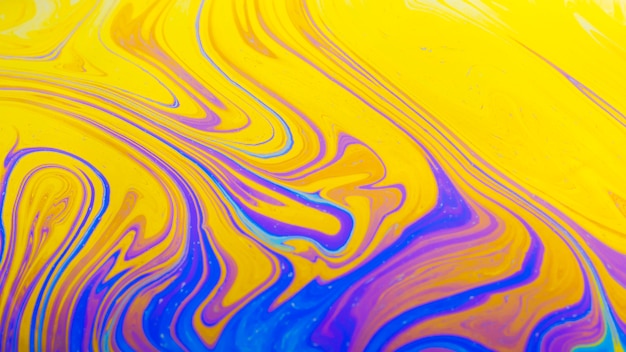 きらめく波状の紫と黄色の抽象的な背景