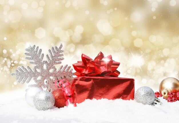 Glittery golden christmas background with decoration in snow