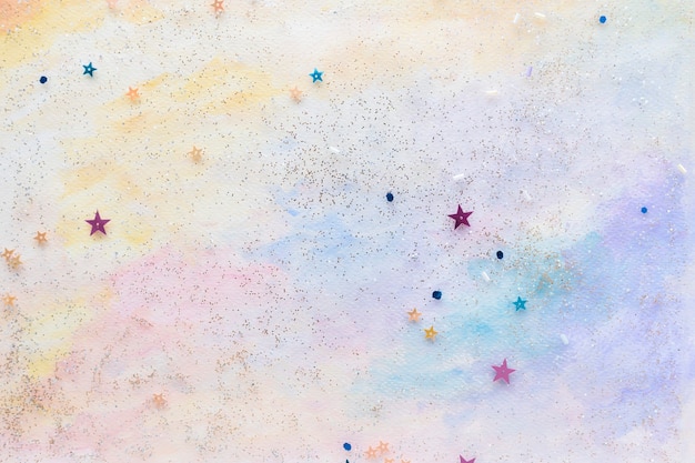 Glittery star confetti on colorful abstract pastel watercolor background