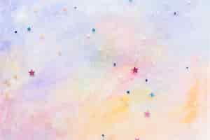 Free photo glittery star confetti on colorful abstract pastel watercolor background