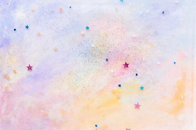 Glittery star confetti on colorful abstract pastel watercolor background