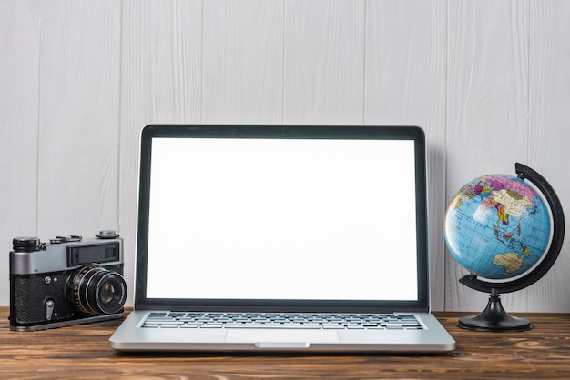 Globe and camera near laptop