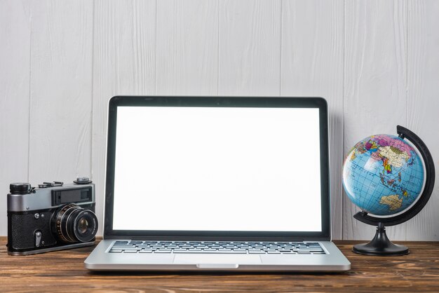 Globe and camera near laptop