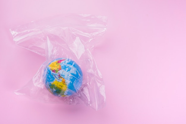 Globe in polyethylene bag over pink backdrop