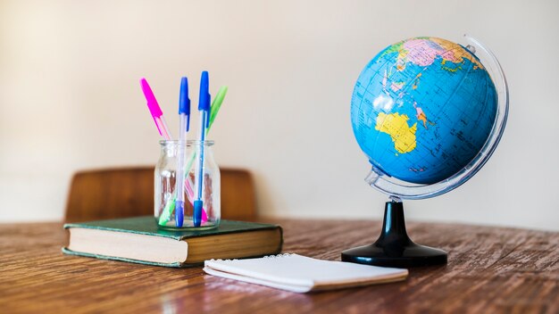 Globe and stationery on table