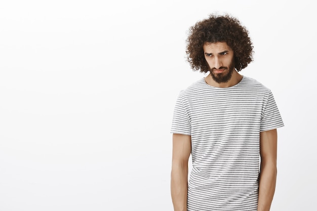 Free photo gloomy desperate handsome male model in striped t-shirt, stooping head and looking down with sad look. giving up after losing