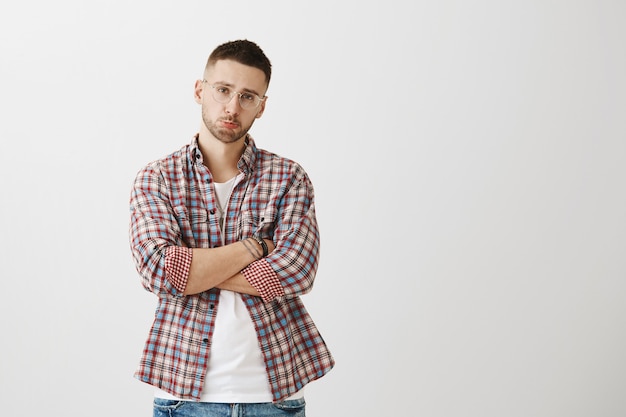 Gloomy and reluctant young guy posing