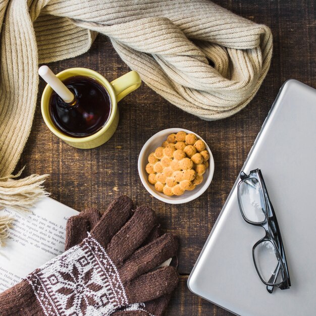 Gloves and scarf near dessert and notebook