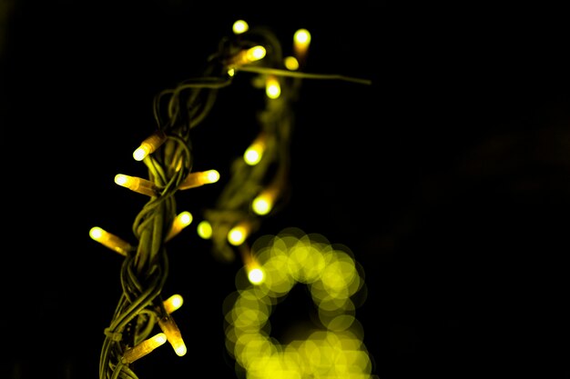 Glowing christmas yellow fairy light against black backdrop