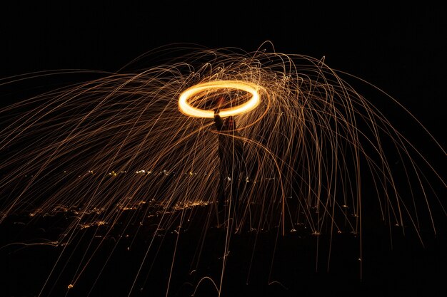 Glowing light extending its sparks into the air as it is rapidly spinning